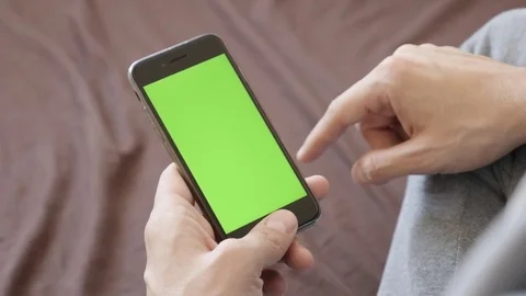 Man holds green screen mobile device and with finger gestures Stock Footage 72254697