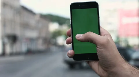 A man holds up a green screen smartphone against Manhattan's busy, 5th Avenue Stock Footage 64577178