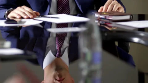 Man holds hands on table with papers pen notebook at meeting Stock Footage 243659317