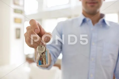 A man holds in his hand the keys of his house, indoor. Stock Photos