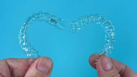 A man holds in his hand transparent aligners plastic braces retainers for s.. Stock Footage 320461325