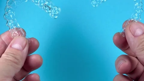 A man holds in his hand transparent aligners plastic braces retainers for s.. Stock Footage 320461349