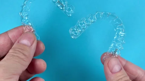 A man holds in his hand transparent aligners plastic braces retainers for s.. Stock Footage 320461358