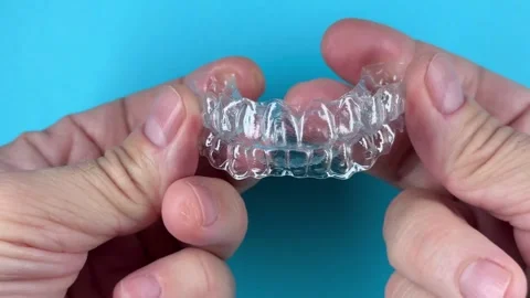 A man holds in his hand transparent aligners plastic braces retainers for s.. Stock Footage 320461373