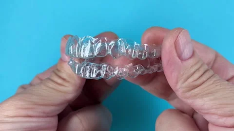 A man holds in his hand transparent aligners plastic braces retainers for s.. Stock Footage 320461415