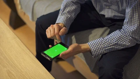 Man holds in his hands a smart phone with green screen. Stock Footage 113457748