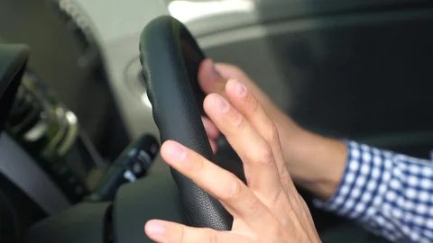 A man holds his hands on the steering wheel in the car Stock Footage 80217697