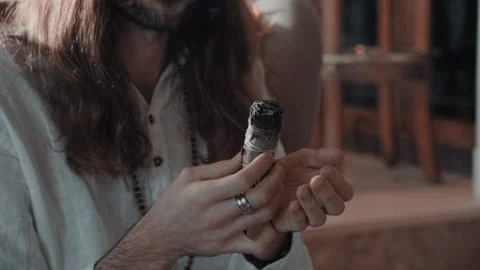 A man holds incense and blows on them Stock Footage 231114934