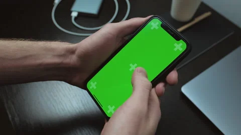 Man holds iPhone with green screen Chromakey . Turning pages, close-up. Stock Footage 133650337