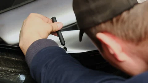 Man holds knockdown tool in hand to affect body of car Stock Footage 316182760