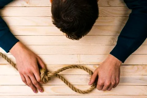 A man holds a loop of rope in his hands. A mental health day Stock Photos