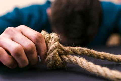 A man holds a loop of rope in his hands. A mental health day. Stock Photos
