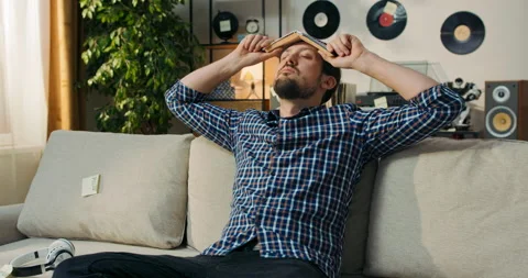 Man holds open book English textbook on head, closes eyes meditates, the magic Stock Footage 200833341