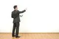 The man holds papers and gestures on the white wall background Photo