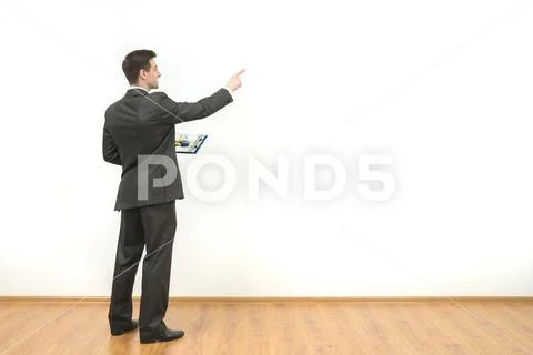 The man holds papers and gestures on the white wall background Stock Photos