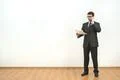 The man holds papers and phones on the white wall background Photo