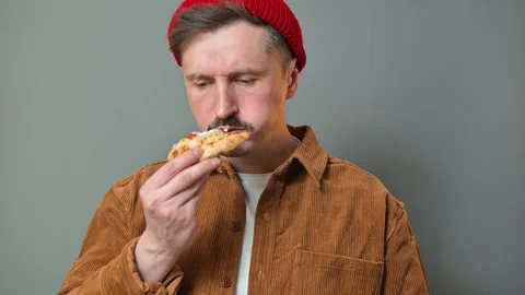 A man holds pizza, tasting it in four distinct frames. His expressions change, Stockbeeldmateriaal 337642710