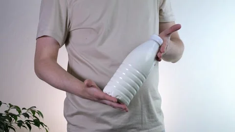 A man holds a plastic bottle with milk. Milk in a mans hands. Agricultural Stock Footage 313189853