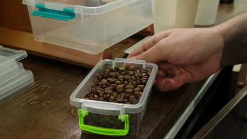 Man holds plastic container with roasted coffee beans Stock-Footage 266281017