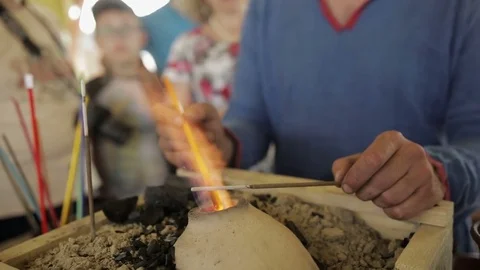 Man holds plastic in his hands and melts it on fire Stock Footage 82358779