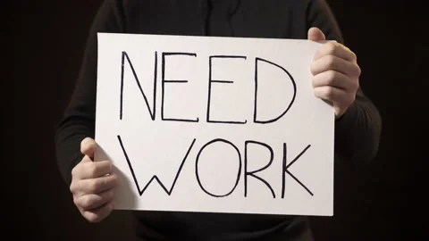 A man holds a poster need work on a black background. Close up Видео 144138459
