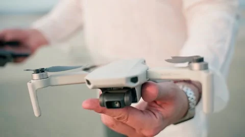 A man holds a quadcopter, the camera zooms in on the quadcopter. Video stock 228684853