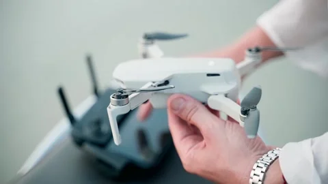 A man holds a quadcopter in one hand, presses the control panel with the other. Video stock 228684874