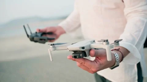 The man holds the quadrocopter and the control panel, the camera slowly moves . Stock Footage 228684862
