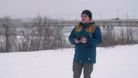 A man holds a remote control from a quadcopter in winter. Control of the Stock Footage 147182028