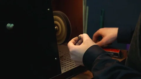 Man holds a ring in his hands and polishes it on grinding equipment Stock-Footage 73813913