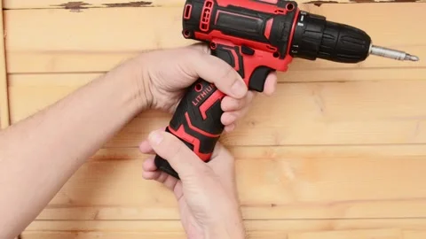 A man holds a screwdriver and inserts a lithium battery into it Video stock 237625624