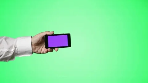Man Holds Smartphone in front of Greenscreen Stock Footage 81484971