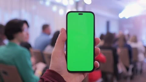 A man holds a smartphone with a green screen in his hand Stock Footage 310224418