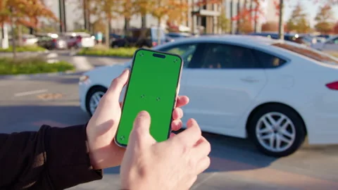 Man holds smartphone using car sharing app against auto Stock Footage 300580727