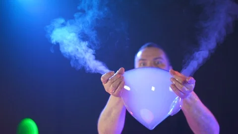 A man holds a soap bubble in his hands and lets smoke out of it Stock Footage 125691212
