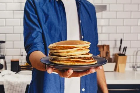 Man holds a stack of fresh baked pankes Stock Photos