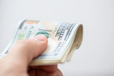 Man holds a stack of hundred dollar bills in his hand, close up Stock Photos