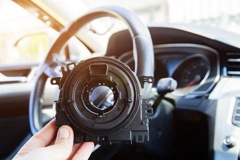 A man holds a steering column cable of a car in his hand against the background Stock Photos