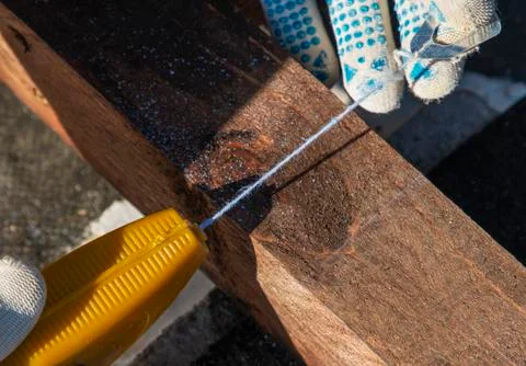 Man holds a thread with chalk for marking a line on a wooden block Foto stock