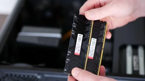 A man holds two black RAM on the background of a PC Stock Footage 245646009