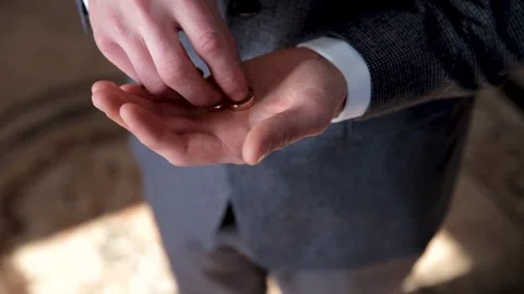 The man holds two rings in his hand and hides them in his pocket Stock Footage 249010424