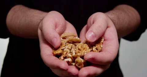 A man holds walnuts in his hands Video stock 238778106