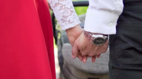 A man holds a woman's hand while walking. Slow motion. Close-up Stock Footage 76101317