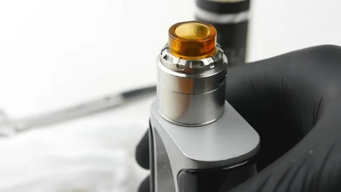 Man holds working electronic cigarette in his hand in black rubber gloves. 스톡 동영상 131853626