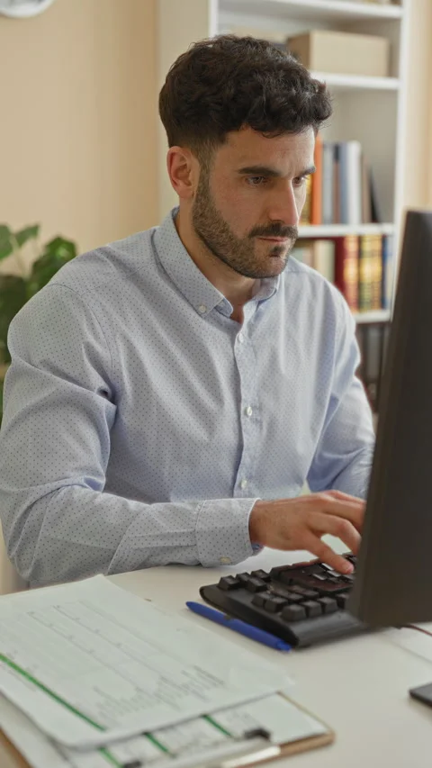 Man holds wrist at computer with keyboard and papers while typing then clut.. Stock Footage 337373480
