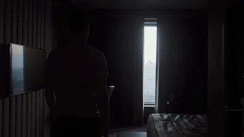A man in home clothes comes to the window and opens the curtains Video stock 123111027