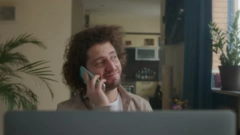 Man at home at the computer, telephone conversation, good news, smile. Stock-Footage 192079528