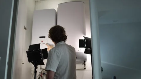 Man at home examining heating boiler and water tank before starting the heating  Stock Footage 318867853