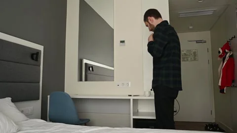 Man at home getting ready for work, buttoning his shirt, drinking coffee Stock Footage 307666871