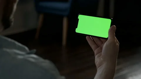 Man at Home Lying on a Couch using Smartphone with Green Mock-up Screen Stock Footage 144685011